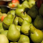Vibrant green pears and apples displayed at a farmers' market.