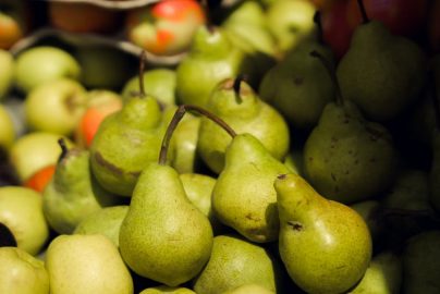 Vibrant green pears and apples displayed at a farmers' market.